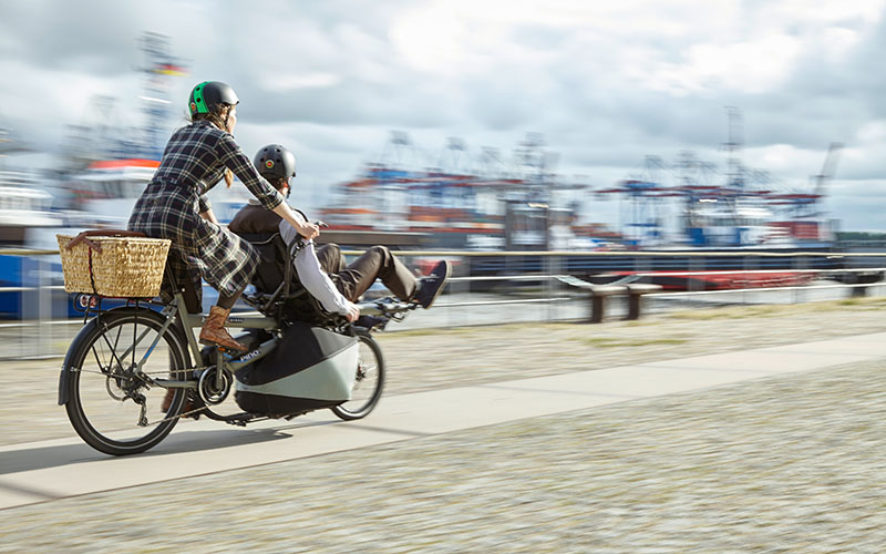 Ein paar fährt auf einem Hase Spezialrad Tandem einem Hafen entlang